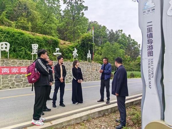 调研团队在二里镇入口处听取当地干部介绍乡村旅游规划.jpg
